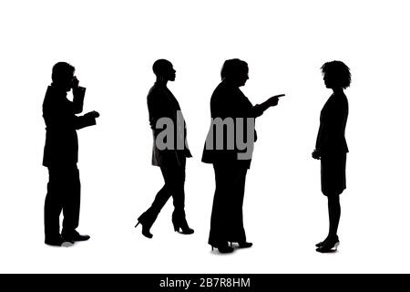 Silhouettes of a group of workers depicting a company or networking event.  The businessmen and businesswomen are unrecognizable and anonymous and rep Stock Photo