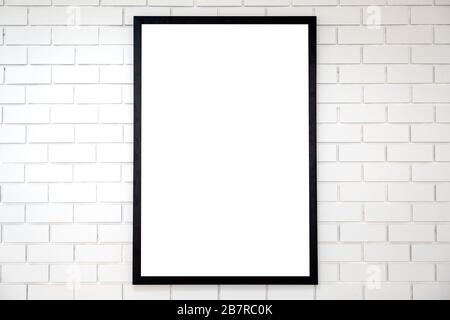 A blank black wooden picture frame on white brick wall background Stock Photo