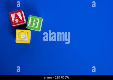A colorful set of Wooden ABC blocks on bright blue background Stock Photo