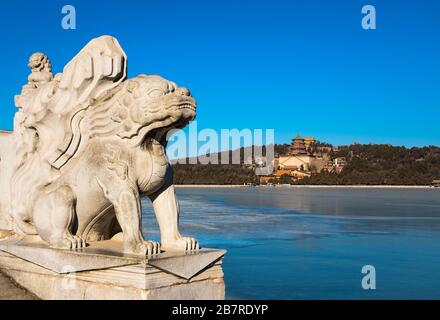 Stone lions on a bridge with palace at distance in Summary palace, Beijing, China Stock Photo