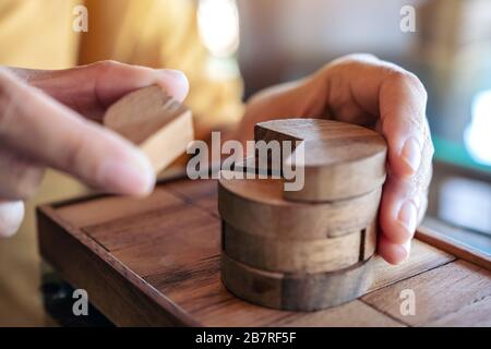 Closeup image of people playing and building round wooden puzzle game Stock Photo