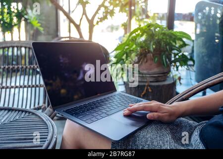 Closeup image of woman's hands using and touching on laptop touchpad while sitting in the outdoors Stock Photo
