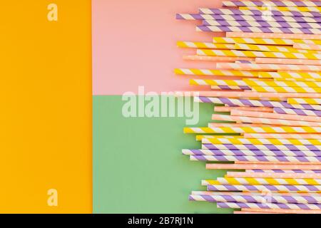 Drinking paper straws on bright background,copy space. Top view of colored paper disposable eco-friendly straws for summer cocktails.biodegradable eco Stock Photo