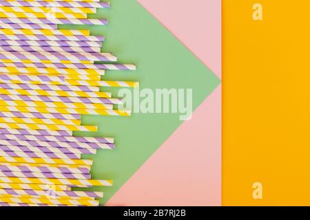 Drinking paper straws on bright background,copy space. Top view of colored paper disposable eco-friendly straws for summer cocktails.biodegradable eco Stock Photo