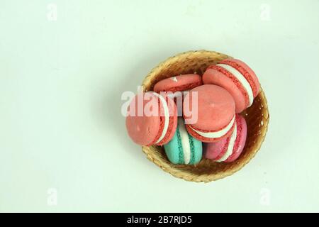 macaroons of different colours in a basket on white background flat lay. Image contains copy space Stock Photo