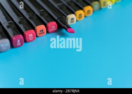 Multi-colored markers on a blue background. Marker for drawing and creativity. Stock Photo