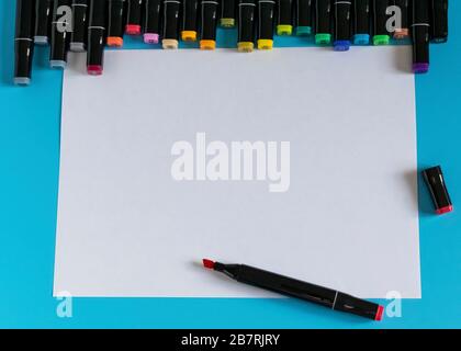 Multi-colored markers on a blue background. Marker for drawing and creativity. Stock Photo