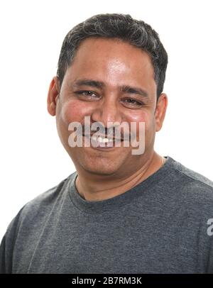 A smiling Indian man in a studio against a white background Stock Photo
