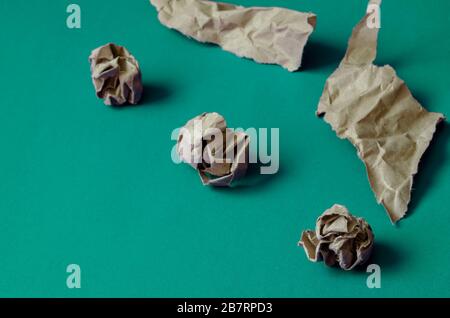 Crumpled and torn pieces of paper on a light turquoise background. Three balls of paper and two crumpled paper pieces. The basis for a variety of desi Stock Photo