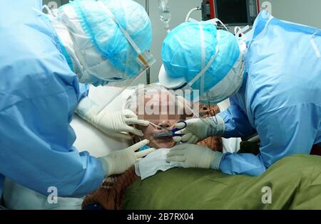 Wuhan, China's Hubei Province. 17th Mar, 2020. Nurses of the ICU (intensive care unit) conduct facial cleaning for a COVID-19 patient at the Huoshenshan (Fire God Mountain) Hospital in Wuhan, central China's Hubei Province, March 17, 2020. During the fight against the COVID-19, medical workers of the ICU of Huoshenshan Hospital work around the clock in rotations to race against time for saving the life of patients of the COVID-19 in severe and critical condition. Credit: Wang Yuguo/Xinhua/Alamy Live News Stock Photo