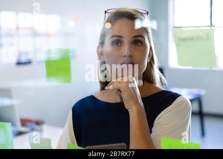 Caucasian woman writing on a sticky note Stock Photo