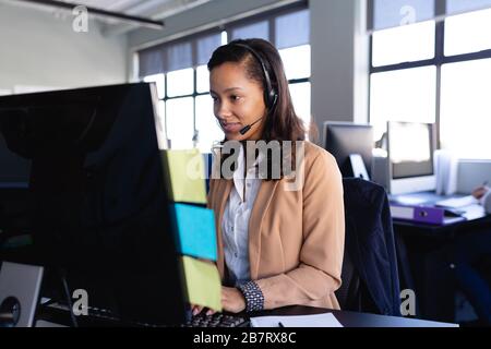 African American woman working with headset phone in office Stock Photo