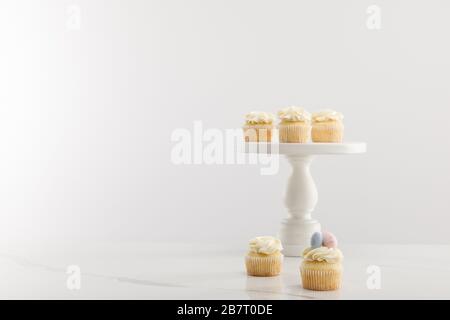 Tasty easter cupcakes on cake stand isolated on grey Stock Photo