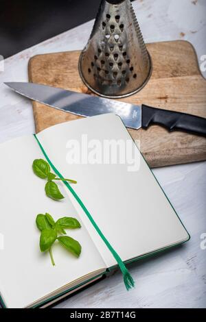 Basil leaveson a desk with a notebook for recipes and notes a composition with negative space a background for advertsing Stock Photo