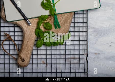 Basil leaveson a desk with a notebook for recipes and notes a composition with negative space a background for advertsing Stock Photo