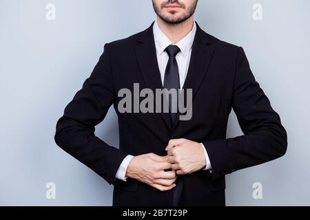 Close up photo of serious confident man in formal black suit and tie buttoning jacket Stock Photo