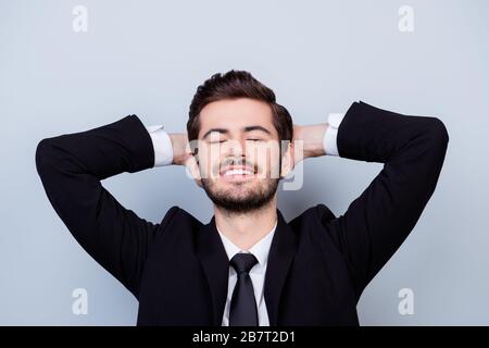 Young happy cheerful smiling man in black suit having a rest after long working day Stock Photo