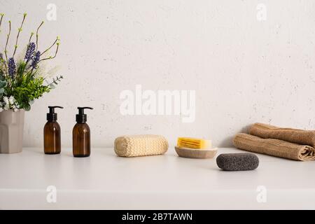 Flowerpot, towels, hygiene and cosmetic products in bathroom, zero waste concept Stock Photo
