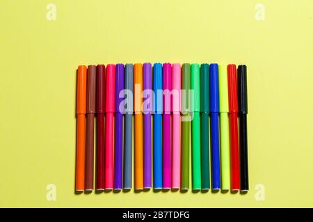 multicolored markers for drawing on a yellow paper background Stock Photo