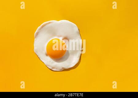 Fried egg on yellow background Stock Photo