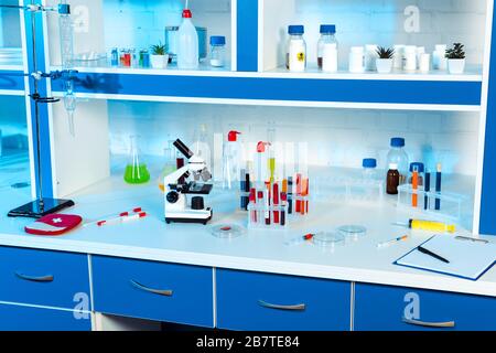 flasks, test tubes and bottles near microscope in modern laboratory Stock Photo