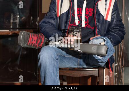 Man with amputation and prosthesis sitting on a pub and drinking a draft beer. Stock Photo