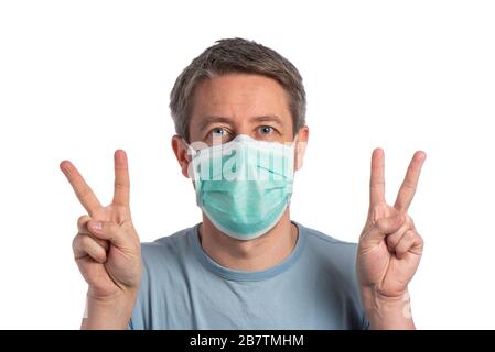 Caucasian man wearing a protection mask and making vistory sign with protective gloves on a white background Stock Photo