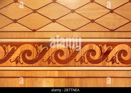 Old wooden parquet with an interesting plant pattern. Decorative wooden tile. Top view grunge wood. Wooden parquet background texture. Warm, yellow, r Stock Photo