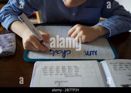Child being homeschooled during the Coronavirus pandemic - learning to write Stock Photo