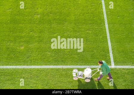 Lining a football pitch using white paint on grass. Stock Photo