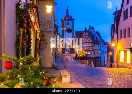 Decorated and illuminated Christmas street with gate and tower Plonlein in medieval Old Town of Rothenburg ob der Tauber, Bavaria, southern Germany Stock Photo