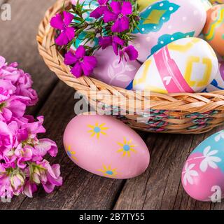 Closeup of colorful flowers and easter eggs on an old wooden surface Stock Photo