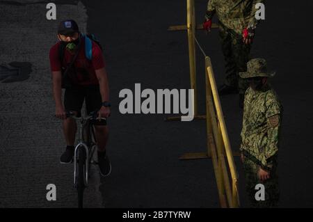 Philippines. 18th Mar, 2020. A commuter on his bicycles passes a police barricade in DM Guevarra St. (Libertad) corner EDSA in Mandaluyong City on Wednesday, 18 March 2020. Luzon Island is currently under enhanced community quarantine suspending all transportation and works. On Tuesday, 17 March, President Rodrigo Duterte has placed the entire nation under state of calamity in order for the government to respond properly to the rising cases of COVID-19 in the country. (Photo by Larry Monserate Piojo/Sipa USA) Credit: Sipa USA/Alamy Live News Stock Photo