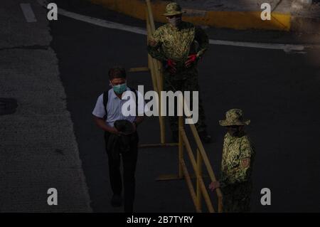 Philippines. 18th Mar, 2020. A pedestrian walks pass a police barricade in DM Guevarra St. (Libertad) corner EDSA in Mandaluyong City on Wednesday, 18 March 2020. Luzon Island is currently under enhanced community quarantine suspending all transportation and works. On Tuesday, 17 March, President Rodrigo Duterte has placed the entire nation under state of calamity in order for the government to respond properly to the rising cases of COVID-19 in the country. (Photo by Larry Monserate Piojo/Sipa USA) Credit: Sipa USA/Alamy Live News Stock Photo