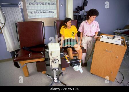 Austin Texas USA: Hispanic teen girl performs exercise during physical therapy session to rehabilitate her injured knee.  MR   ©Bob Daemmrich/ Stock Photo