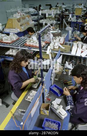 Nuevo Laredo, Mexico:  Mexican workers make repairs on telephones at AT&T maquiladora facility, twinned with a similar plant just across the border in Laredo, Texas.  ©Bob Daemmrich Stock Photo