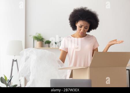 African american girl unhappy at delivery from online store Stock Photo