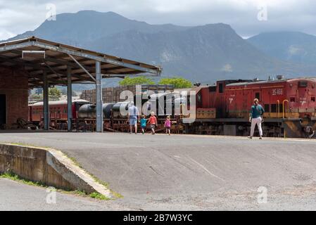 Elgin, Western Cape, South Africa. Dec 2019. Elgin station in the Overberg region of the Western Cape, visitors looking at a vintage steam engine Stock Photo