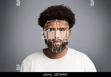 Facial recognition. African American man with polygonal mesh on his face against grey background Stock Photo