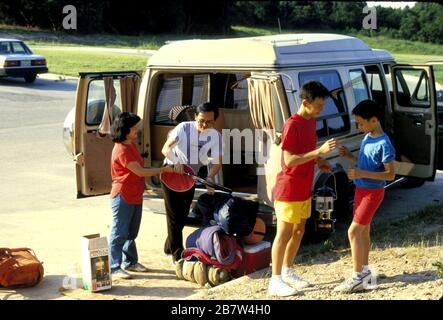 Austin, Texas: Vietnamese-American family loading supplies into their vehicle for camping trip. ©Bob Daemmrich Stock Photo