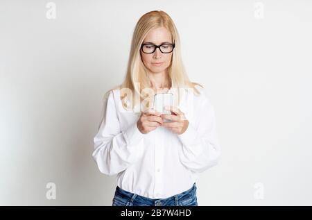 Mature woman reading message on her phone Stock Photo