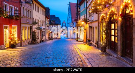 Panoramic view of Christmas street with gate and tower Plonlein in medieval Old Town of Rothenburg ob der Tauber, Bavaria, southern Germany Stock Photo