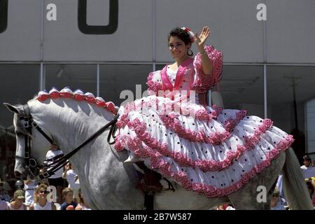 San Antonio, Texas USA:  Young woman wearing dress decorated with flowers rides a horse side-saddle during the 'Battle of the Flowers' parade, part of the city's annual springtime Fiesta celebration. ©Bob Daemmrich Stock Photo