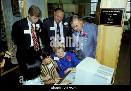 Austin Texas USA: IBM executives, watching students working on a computer in the Walnut Creek Elementary library, attend a ceremony thanking the computer giant for donating computers to the school.  ©Bob Daemmrich Stock Photo