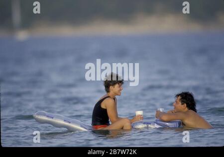 Near Austin Texas USA: Couple talking while relaxing on inflatable raft in water at Lake Travis on hot summer day. ©Bob Daemmrich Stock Photo