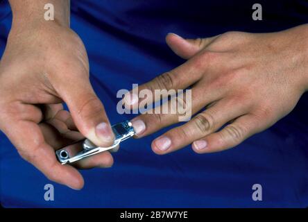Austin, Texas USA: Hispanic teen cutting fingernails properly. ©Bob Daemmrich / Stock Photo