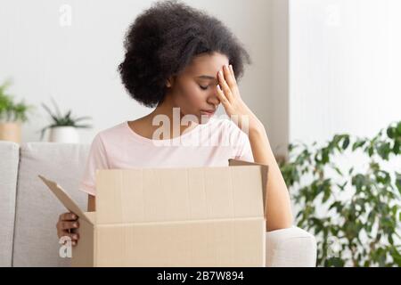 African american sad woman presses her hand to forehead Stock Photo