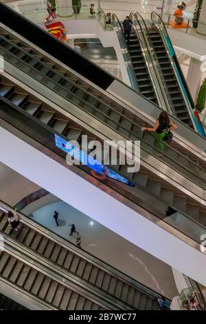 Large intersection of escalators inside a large, modern multi-storey mall in an eastern metropolis Stock Photo