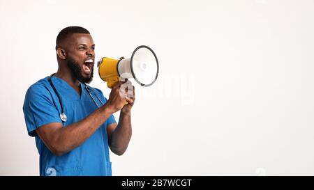 Angry black doctor in blue uniform using speaker Stock Photo