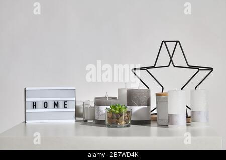 Table with green succulent in glass pot, some candles, lamp with inscription home, black iron star, jar with a wooden lid and copy space. Isolated on Stock Photo